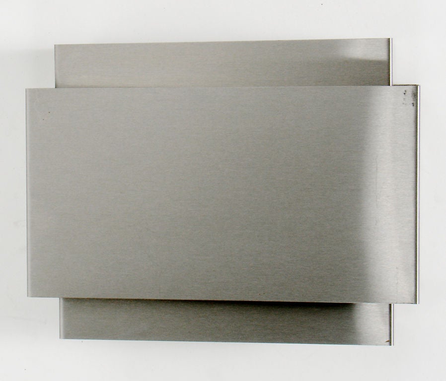 Appliques minimalistes en métal brossé, probablement françaises, vers les années 1970. La conception des persiennes permet de diffuser une lumière vers le haut et vers le bas, ainsi qu'une lumière diffuse sur la persienne avant. Chaque applique a
