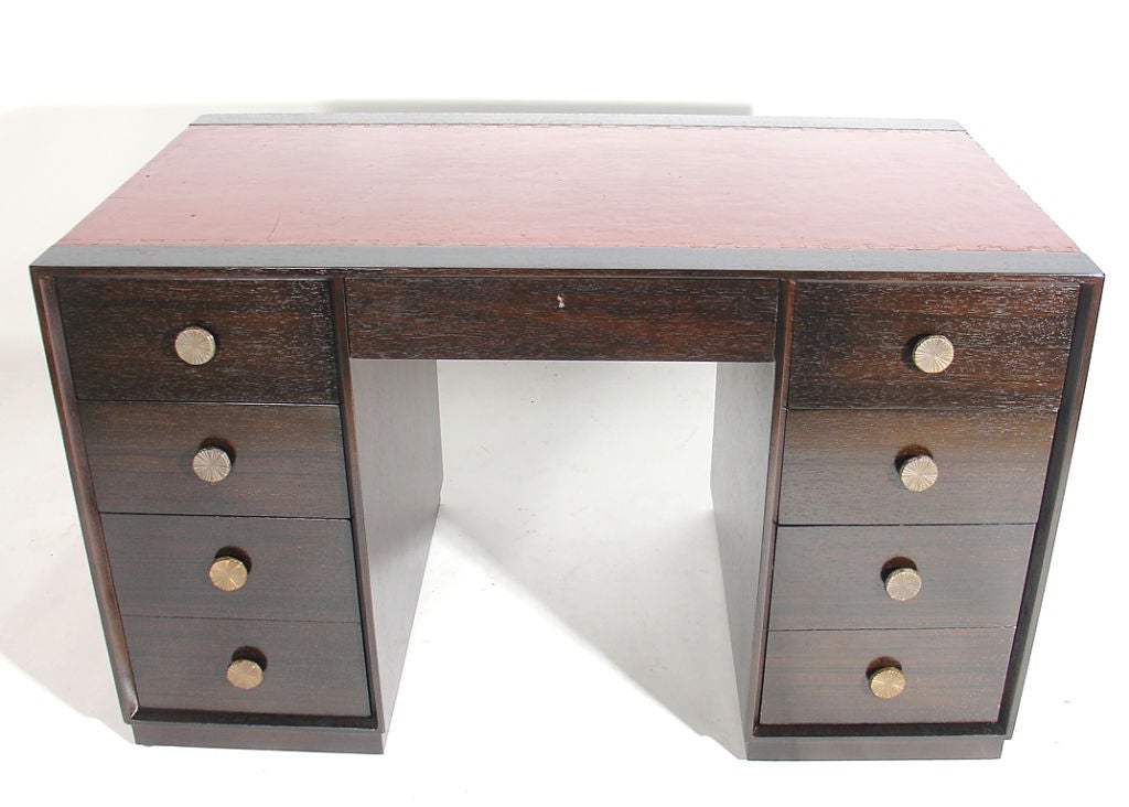 Elegant Modern Desk, designed by Tommi Parzinger for Charak, circa 1950's. It retains it's wonderfully patinated burnt orange leather top and is refinished in an ultra-deep brown lacquer. As it is finished on both sides, it can be floated in a room.