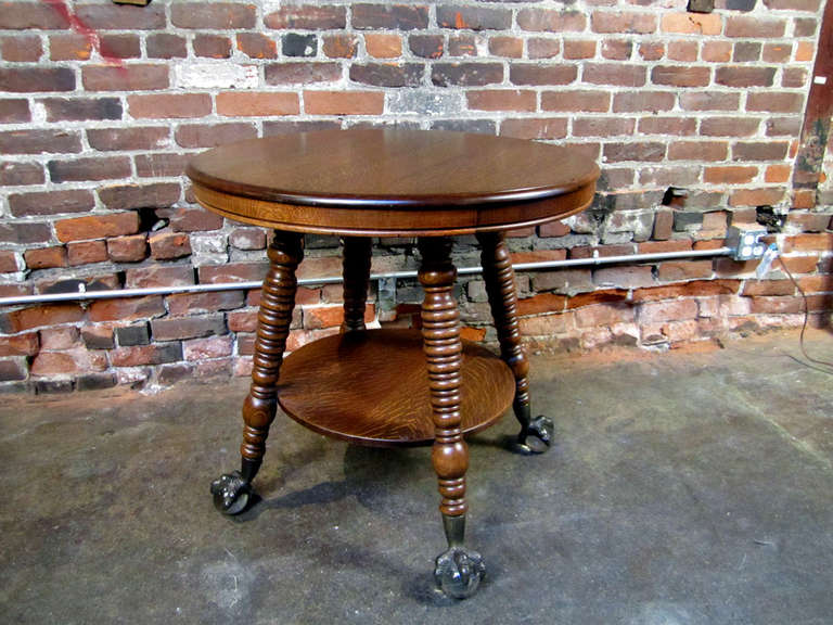Fantastic, round, quarter sawn oak parlor table with shelf.  Thick striping in the oak, and boldly dressed with talon claw feet, covering 4