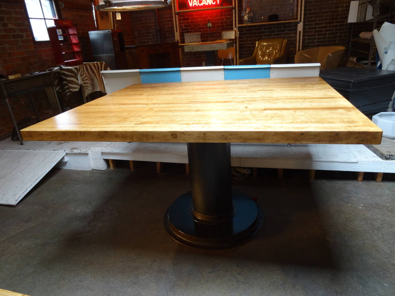 Solid, maple top, found in a school wood working shop.  United with a custom steel base, this piece makes an bold statement as an island, work table, retail piece, or dining.