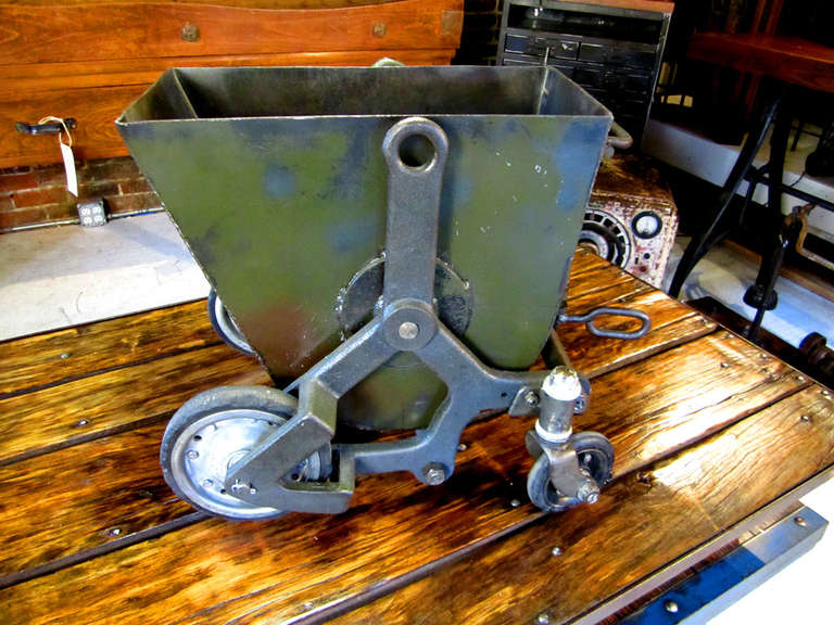 Heavy cast iron and steel bucket cart.  Handle release to a dump position as seen in image 3.  Excellent for magazines, firewood or other storage.  This is rare and very cool.  Could be from a mine, railroad, or other heavy-duty, industrial