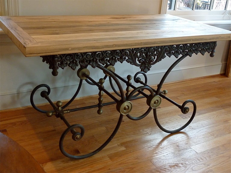 19th Century French Provincial Cast Iron Butcher’s Table . Ornate cast frieze over gracefully scrolled steel legs with the original brass fittings and finials. Contemporary 2” thick top made of reclaimed oak. Traditionally used for display . Made in