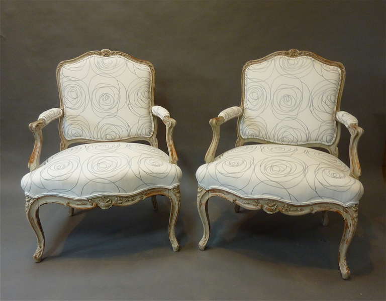 Pair of Louis XV Style French Provincial Armchairs. Made of beech retaining old painted finish with delicate carved floral decoration enhancing graceful arms and shaped cabriole legs. Good generous proportions with contemporary fabric. Made in