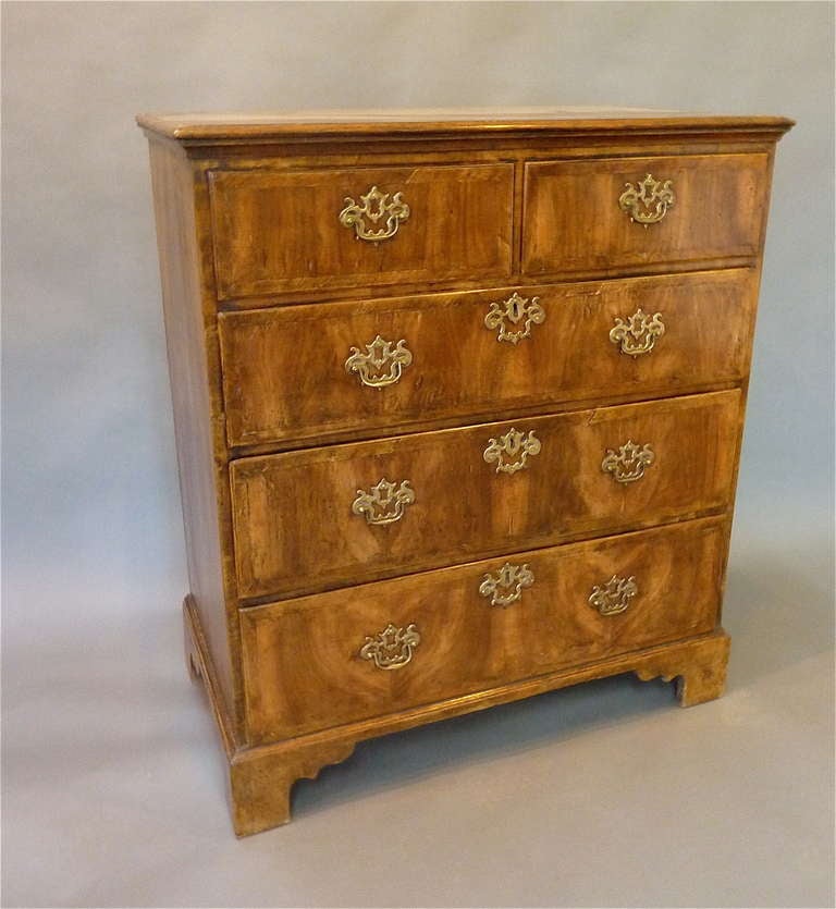 A Fine George I Period Walnut Chest of Drawers.  The molded top is quarter-veneered and crossbanded above two small drawers and three further graduated drawers.  Each crossbanded drawer is book-matched in highly figured walnut and edged with a