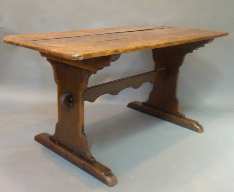 Early 19th Century Rustic Welsh Tavern Table. Framed top made of Sycamore with a warm cinnamon color and rich patination. Trestle base made of walnut with shaped uprights  joined with a scalloped stretcher. Made in Wales circa 1820