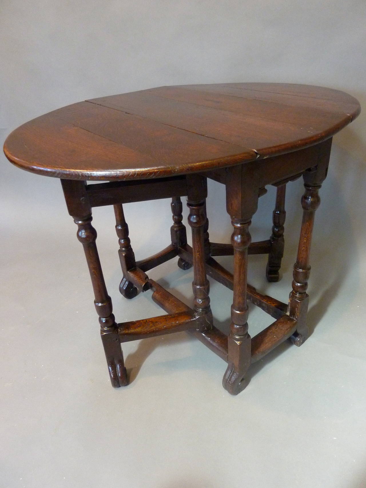 A Small Charles II Period 17th Century Gateleg Tavern Table. Made of richly patinated oak with a deep lustrous color. Unusual small proportions with elegant turned legs and carved scroll feet. Purchased from a pub in Oxfordshire.  Made in England