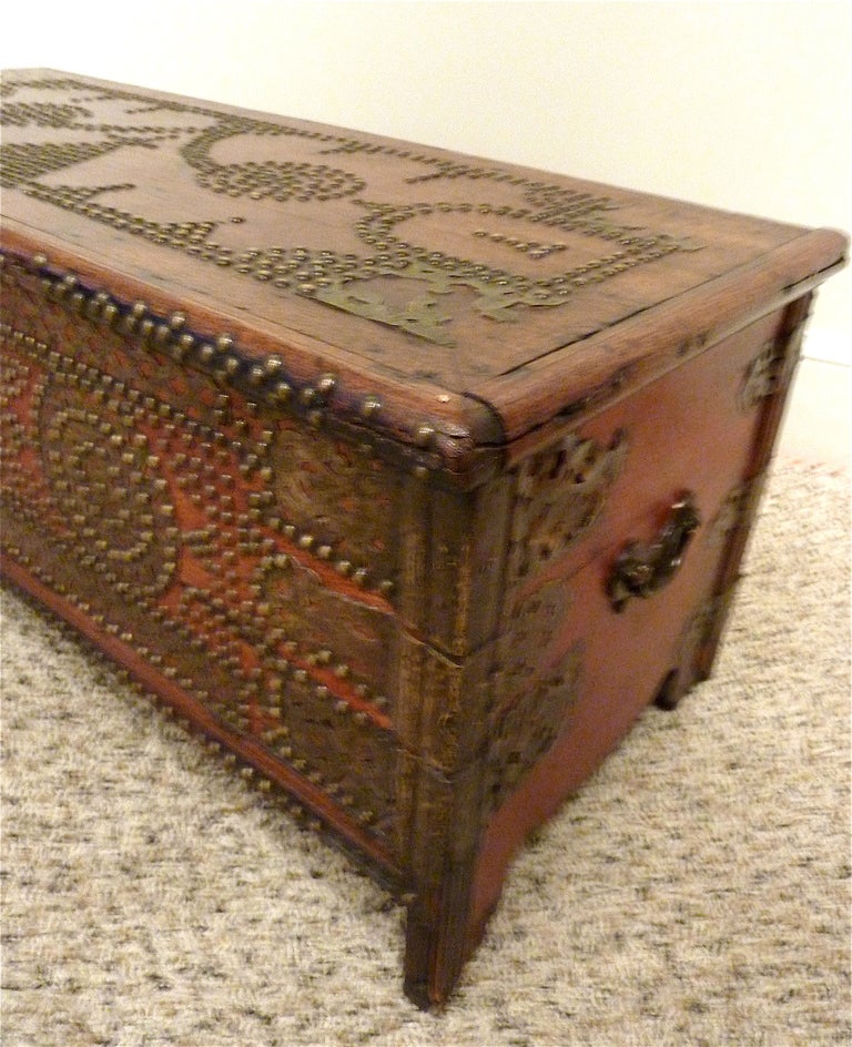 Rare 18th Century East African “Zanzibar” Chest. Decorated with remarkable pierced brass and brass nail heads in geometric patterns on teak with a cinnabar red pigment. Interior shaped brass hinges and secret compartment. Made in Zanzibar circa 1790.