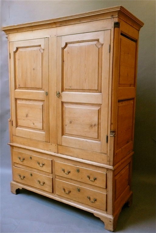 Fine Quality Irish Linen Press. Made of pine with two cupboard doors with shaped fielded panels flanked by quarter colomns over four drawers retaining the original hardware above shaped bracket feet. Made in Ireland circa 1780.