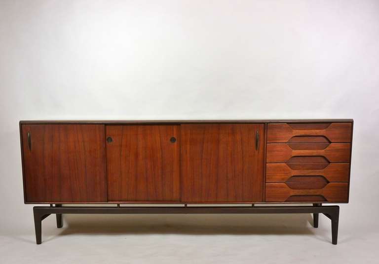 Teak and rosewood credenza by Arne Hovmand-Olsen for Mogens Kold. Teak cabinet with four drawers and sliding doors concealing interior shelves. Designed to appear floating upon a rosewood base, Denmark.