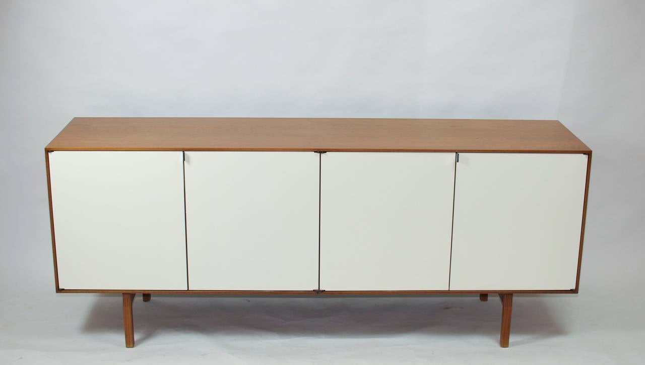 Florence Knoll walnut credenza with white lacquered doors.
Two available.