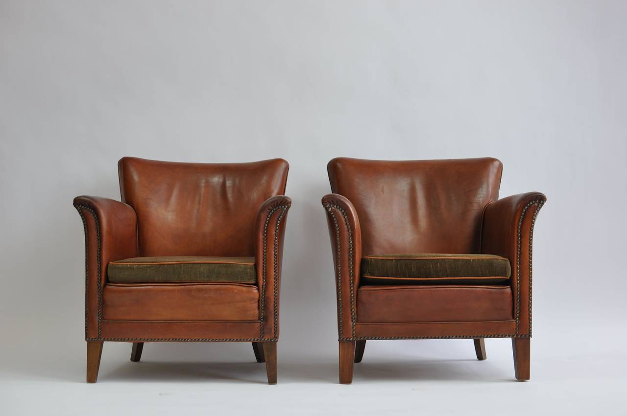 Pair of 1930s Danish leather club chairs. Original leather with beautiful patina. Velvet seat cushions with leather piping.