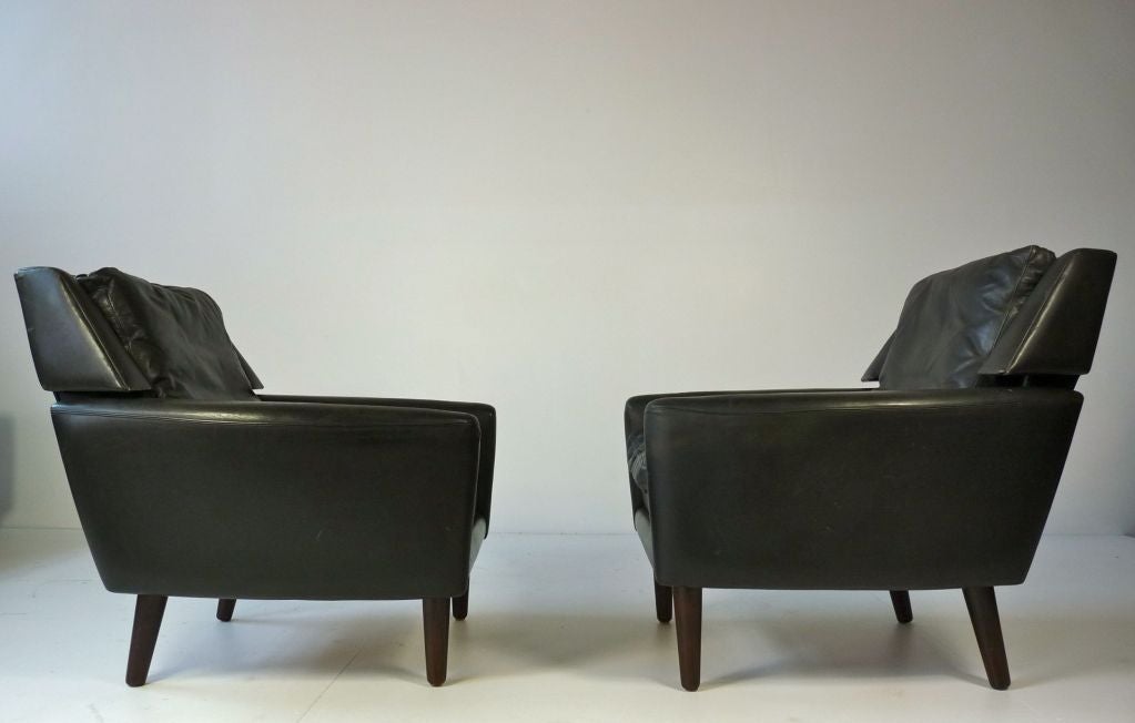 Pair of Danish lounge chairs with original black leather. Rosewood legs.  Matching sofa also available.