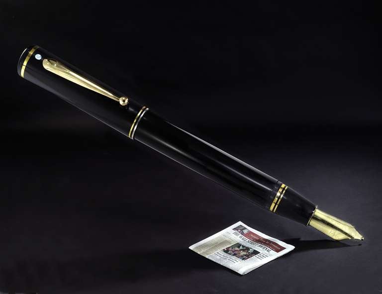 An enormous display model of a Sheaffer Connaisseur Fountain Pen in resin with engraved brass nib.  Complete with chain for hanging from a wall.