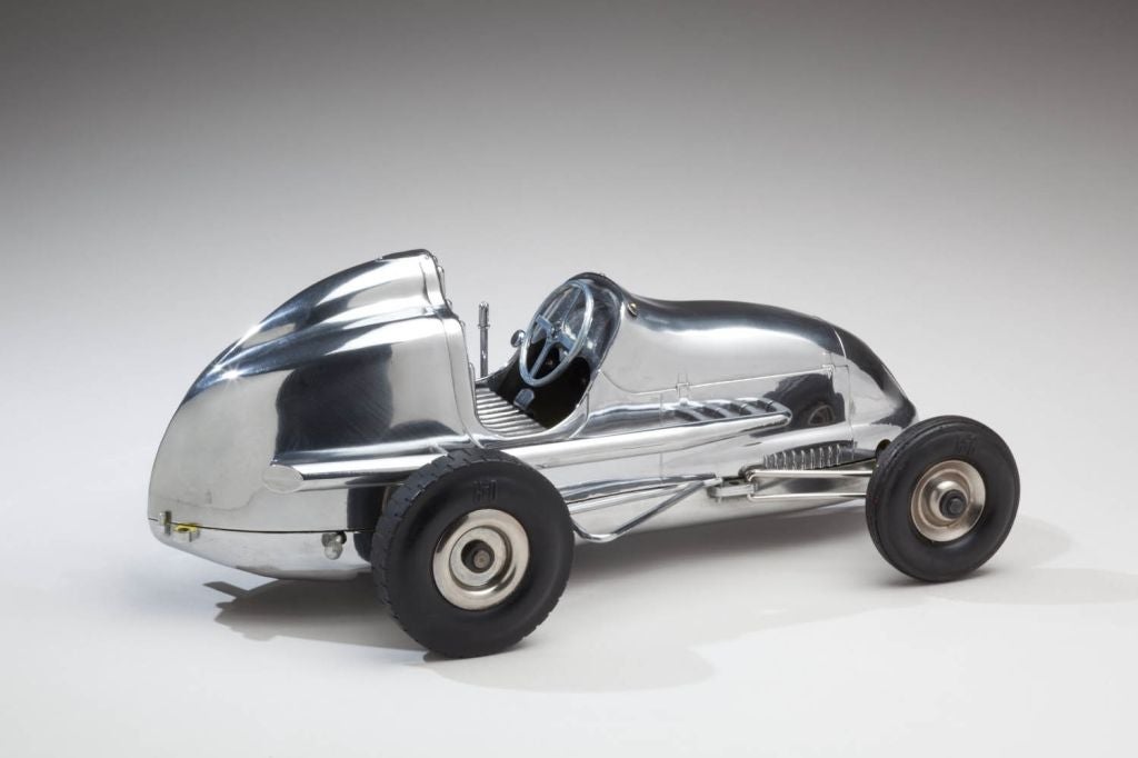 These three exceptional late 1940s gas-powered model race cars in polished aluminum, each with a model airplane engine for power, were designed to be connected by a tether wire to a post in the ground and raced around a circular track, where they