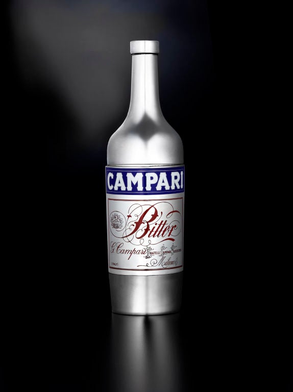 A rare and superb silver and enamel cocktail shaker in the form of a Campari bottle, the removable cap embossed DAVIDE CAMPARI MILANO, the base stamped R. Miracoli & F and 800 (Romeo Miracoli & Sons, Milan).  The back of the shaker is engraved:<br