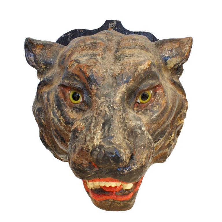 This paper mache tiger head from the 1920's features glass eyes and a fantastic vibrant original paint surface. Presented on original black painted wood shield mount. Likely a circus or carnival piece. Found in the Midwest.