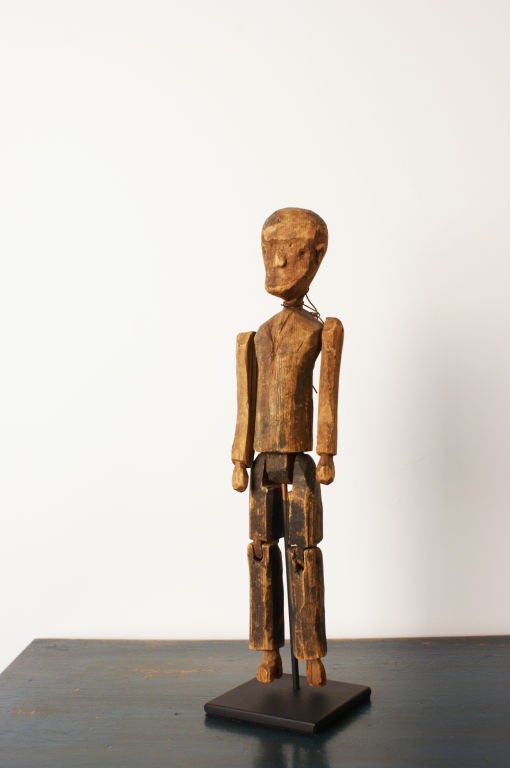 This primitive painted wood articulated figure has been simply carved and wears a solemn expression on his face. Found in the southern US. Presented on a custom museum stand.<br />
<br />
One in a collection of four. See Image 8.