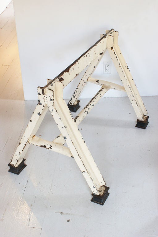 c. 1940's heavy industrial iron sawhorses with great battered white paint surface. Would make for an amazing table or desk base.