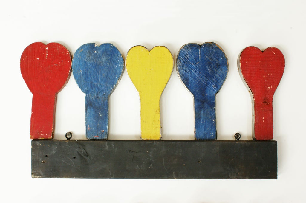 Crudely cut and painted in red, yellow, and blue, these doweled hearts fit into black painted boards and were used for a ring toss game in a mid-century Midwestern carnival. Some of the hearts were reinforced with strips of sheet metal along their