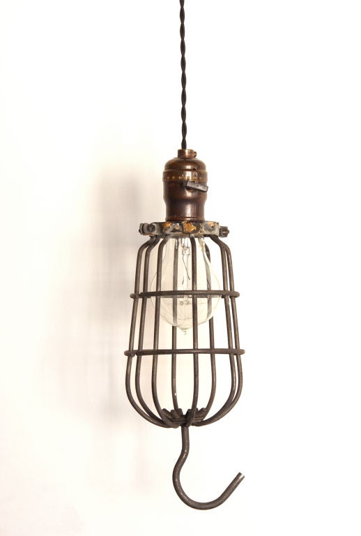 Original vintage cage light with reproduction sockets in a hand rubbed antiqued brass finish with flat turn keys and 9 ft. cloth cords. Please Note: Priced and available individually. Slight variations between individual lights. Currently three