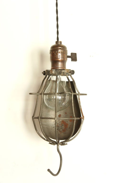 Original vintage cage light with a metal reflector shield. Reproduction socket in a hand-rubbed antiqued brass finish with flat turn key and 9 ft. cloth cord. Please Note: Priced and available individually. Currently one available.

Given the