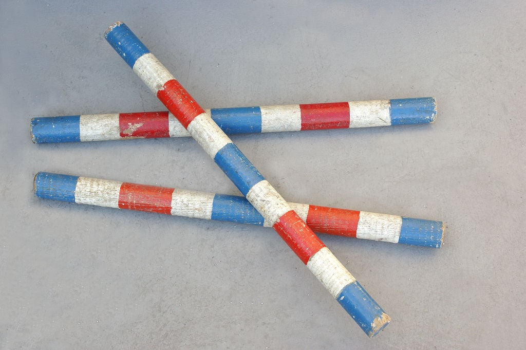 Set of three red, white, and blue painted wooden batons, most likely used as circus props for juggling.