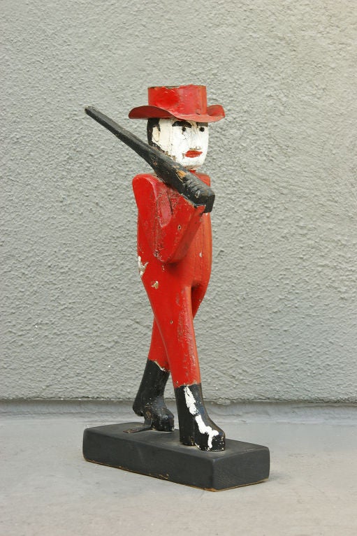 Handgeschnitzter hölzerner Folk-Art-Jäger mit einem Hut aus Blech. Original rot, weiß und schwarz lackierte Oberfläche.