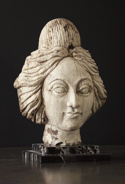 Late 19th century American carnival wagon or band organ female head carving. Very detailed wood carving with great old white painted surface. Presented on a custom marble museum stand.