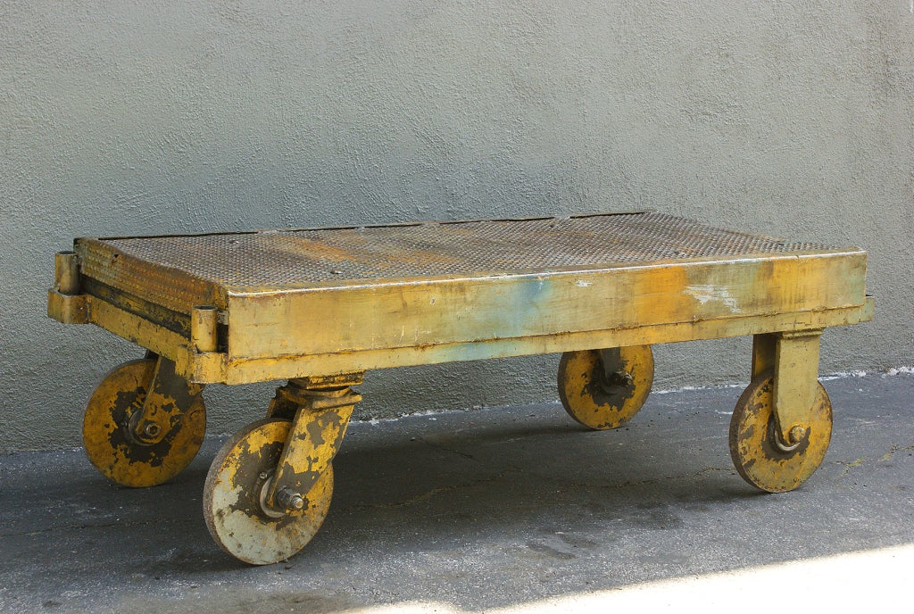 Very sturdy and functional industrial trolley from midwestern factory.  All iron and perfect coffee table scale.   Very graphic skid plate surface on the top.