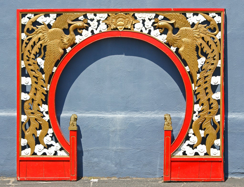 Impressive and grand arch that graced the entry of a Chinese restaurant in the 1940s American Midwest. Impressively carved and double-sided solid wood. Original paint surface with great lipstick red borders. A stately pair of golden Foo dogs watches