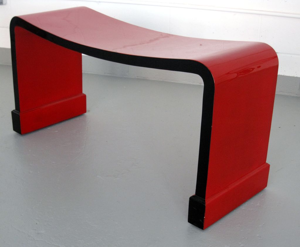 A bench in the style of Eileen Gray in very high quality red and black lacquer.