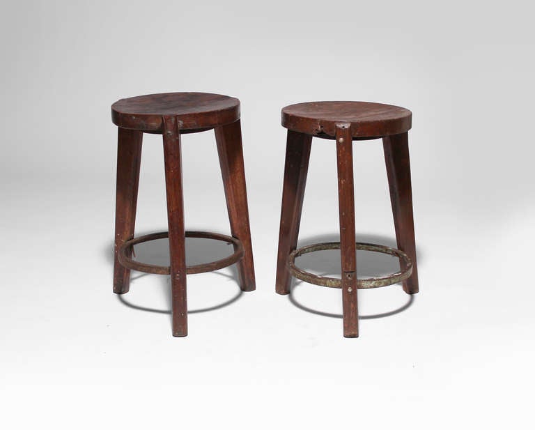 Pair of teak circular stools with wood seat, three flared legs and metal ring support. Punjab University, Chandigarh, India, c. 1965.  Le Corbusier Pierre Jeanneret: The Indian Adventure, Design-Art-Architecture, Touchaleaume and Moreau, pg. 560.