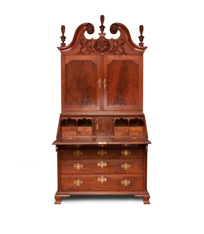 This example of Philadelphia craftsmanship demonstrates what the finer hands of this period could do with a secretary desk.  A scrolled top with three urn and finials are all nicely complemented by vine carving surrounding a bold carved center shell
