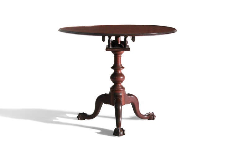 An exceptional example of the Philadelphia tea table form. This piece in an old finish has a bold dish top, a birdcage and suppressed ball pedestal over cabriole legs terminating in claw-and-ball feet.