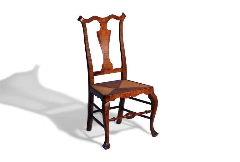This is an excellent example of a tiger maple side chair attributed to William Savery. It has a cupid’s bow crest, spooned back with solid splat, rush seat and elaborately scalloped aprons. Cabriole front legs terminate in “crook’t” feet. The front