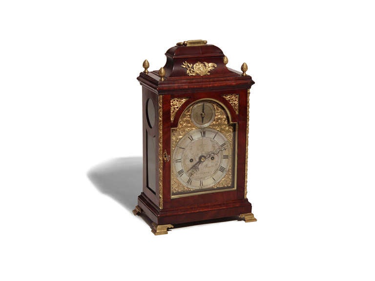 An exceptional bracket clock with a brass dial and an 8-day pull-quarter-repeat.  It has brass finials and a brass handle on the top.  There are nicely gilded quarter columns and there are brass ogee feet.  It has a silent strike and is signed by