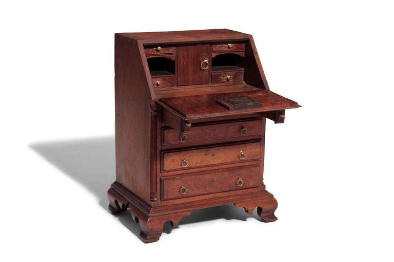 An exceptional example of a miniature piece of furniture.  Bearing all the desirable features of a Chippendale slant front deak, this desk has a four drawer arrangement, fluted quarter columns and Chippendale feet.  There is a nice interior with a