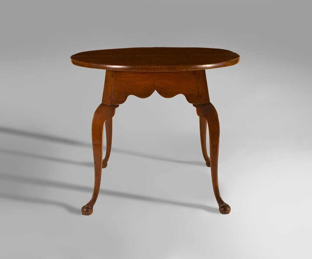 This charming and rare tavern table has unusual grace.  With nicely scalloped aprons and four splayed cabriole legs terminating in claw-and-ball feet.  One similar to it is pictured in 