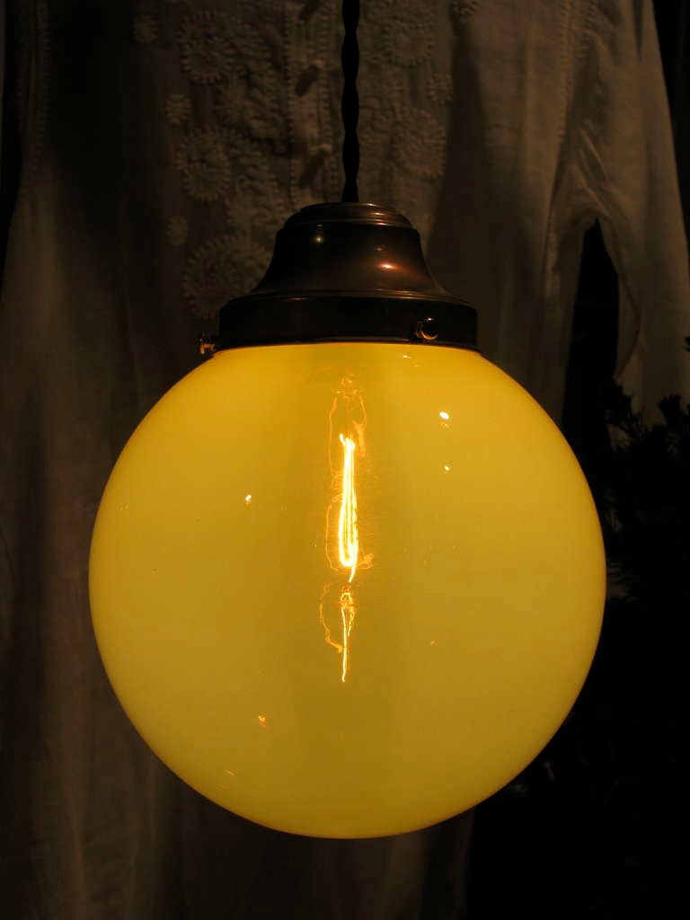 Beautiful Oversized Vaseline Glass Globe
Pendant light casts a warm glow and can be used depending on bulb wattage as task light, decorative or utilitarian applications
Newly rewired with antique brass fitter and black braided cloth cord. 
Custom