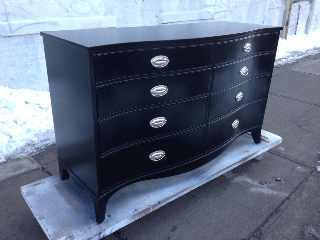 Wave front eight-drawer black dresser with nickel pulls, with miniature Klismos legs.  The blue is the reflection of the sky.
