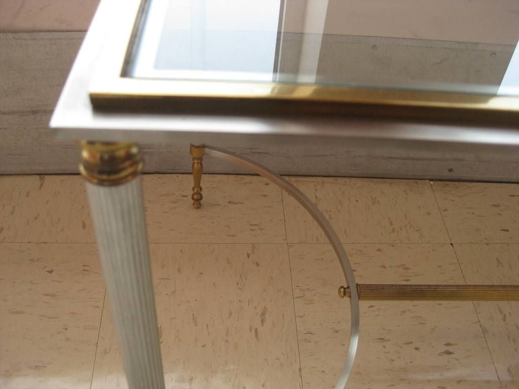 Hollywood glamour center table in the manner of Maison Jansen, this Mid-Century Modern era, occasional end table is in the Directoire style brass and chrome bi metal combination, this table is in excellent vintage condition.
