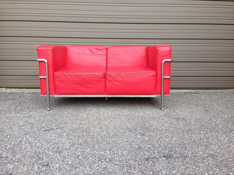 Single or pair of red lounge chair and loveseat in the style of le corbusier for Cassina, excellent quality of leather and craftsmanship, the settee measurements are
 H26.5 D33 and W54.5