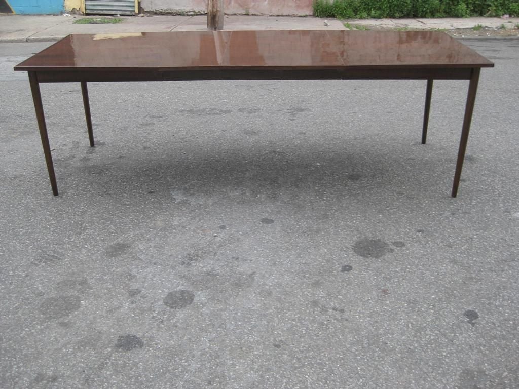 Exceptional elongated subtle hexagonal or octagonal bookmatched Mid-Century Modern dining table after Paul McCobb, with subtle banding on far ends and three leaves, each leaf at 12