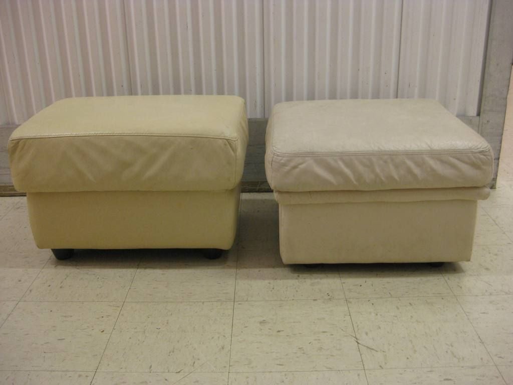 Unmatched pair of Mid-Century Modern European leather ottomans poufs.