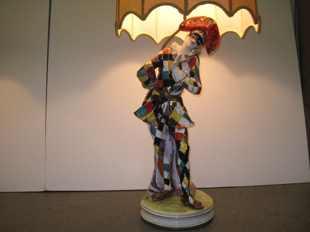 Exceptional and whimsical pair of large Italian porcelain table lamps, with Masquerade figurine characters and umbrella shape silk shades, in the style of Capodimonte.