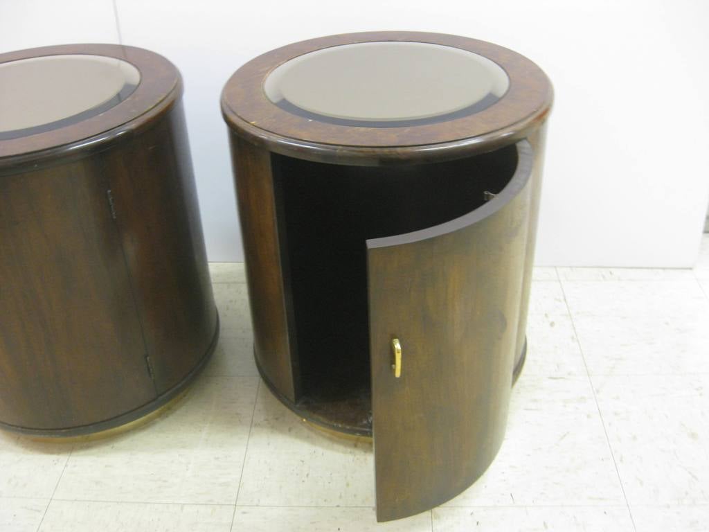 Pair of mirror inset drum bedside end tables, with brass banding on base.