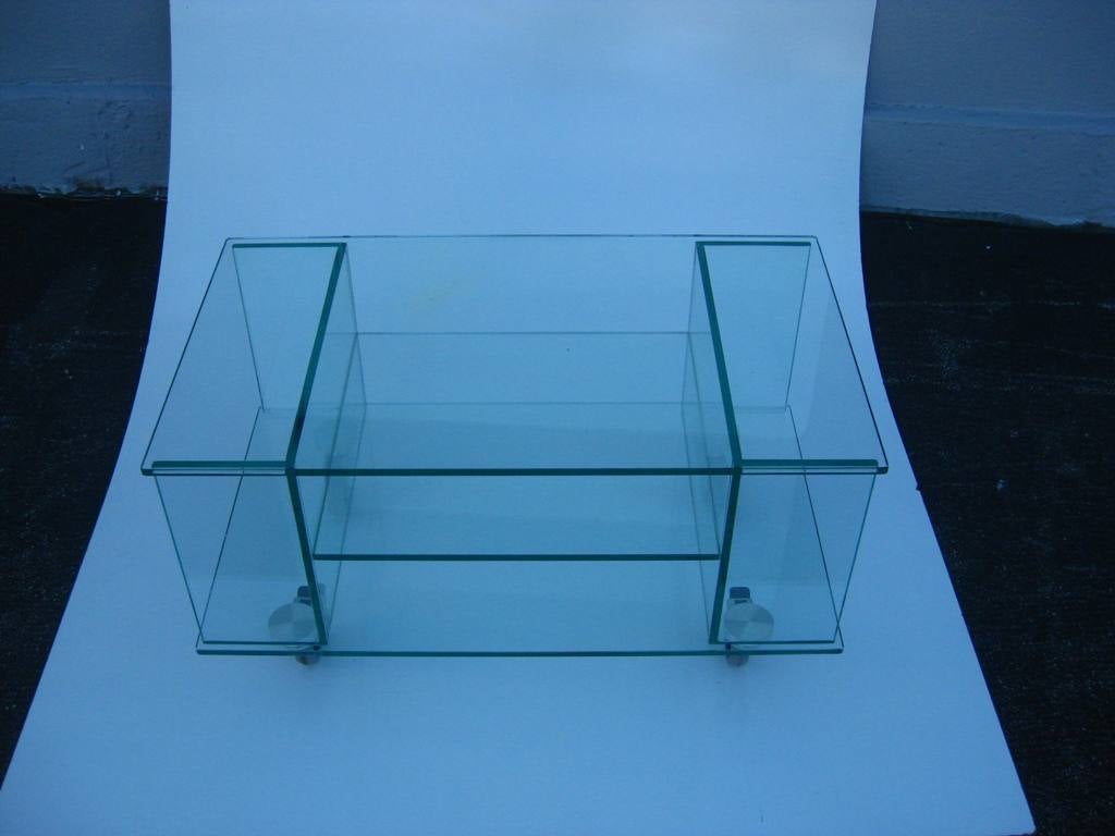 Excellent glass work gives this Mid-Century Modern rolling side or coffee table a clean look with as many as (4) storage compartments and top surface with two locking casters attributed to Fontana Arte, this item is now on sale for a clearance price.
