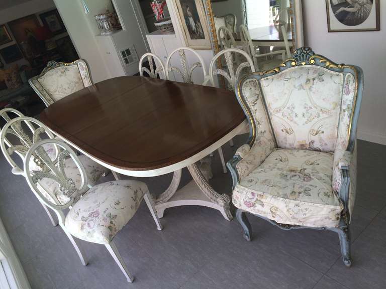 Gorgeous vintage dinning room set with a feather and bow motif design.Walnut top with white washed base comes with 2 leaves.Double feather design bases with 2 arm chairs and 4 side chairs recovered in beautiful vintage floral fabric.
Also shown are