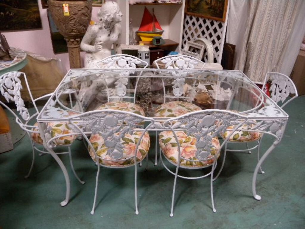 A FABULOUS VINTAGE PATIO SET....  1950's patio dining table along with five side chairs and one arm chair. The heavy, cast iron is the POMEGRANATE Pattern that extends into the table top surface, the apron of the table, along with the wide detailed