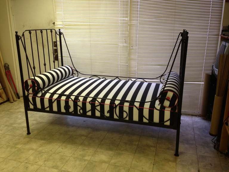 Fabulous 19c black Iron day bed.Can be used indoor or outdoor. Sunbrella black and white stripe fabric trimmed in pink Sunbrella fabriic.Comes 2 matching bolsters...